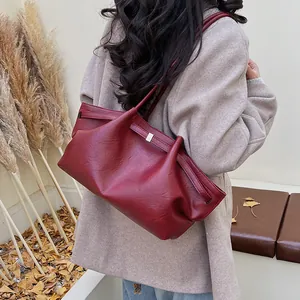 Détail du sac cabas en cuir bordeaux montrant la texture plissée et la boucle en métal