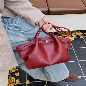 Vue détaillée du grand sac cabas vintage rouge foncé avec boucles dorées élégantes