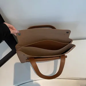 Detail view of the brown leather briefcase showing its multi-compartment interior structure