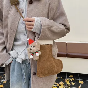 Gros plan d'un ours en peluche avec bonnet de Noël sur un sac en daim marron en forme de chaussette
