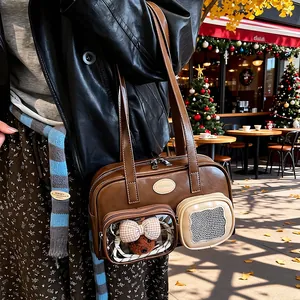 Details einer braunen Vintage-Umhängetasche mit Klarsichttasche und süßem Bären-Anhänger