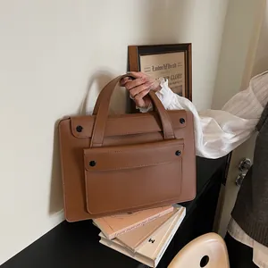 Detailed view of the brown leather briefcase featuring sturdy handles and front flap pocket