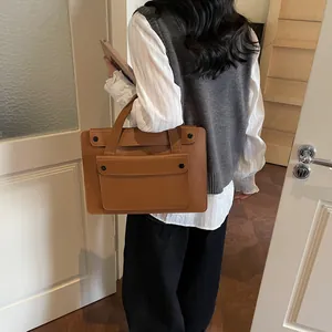 Brown retro leather tote bag with large front pocket and buckles in a lifestyle setting