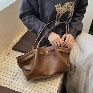 Détail du sac cabas vintage marron montrant la texture fine et la boucle dorée en métal