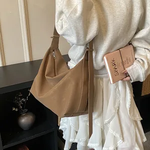 Brown faux leather tote bag with wide shoulder strap shown on a model in a minimal setting