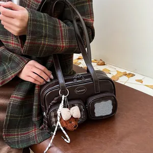 Detail einer braunen Vintage-Einkaufstasche mit Taschen und süßem Teddybär-Anhänger