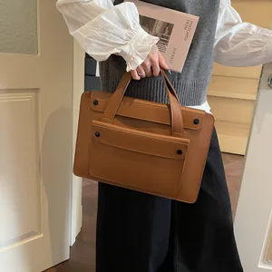 Brown leather vintage briefcase handbag with front pocket shown in a professional setting