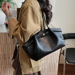 Détail du sac cabas noir avec texture en cuir rétro et boucle métallique décorative