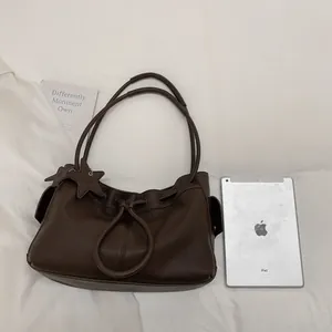Detail view of large coffee brown leather tote bag with iPad for size reference