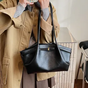 Gros plan sur le cabas en cuir noir avec plis souples et boucle en métal doré