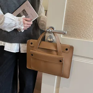 Brown leather business briefcase for women hanging on a door handle in a stylish office setting