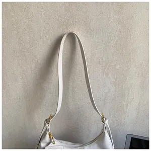 Detail view of white hobo bag with smooth zipper and golden metal hardware accents