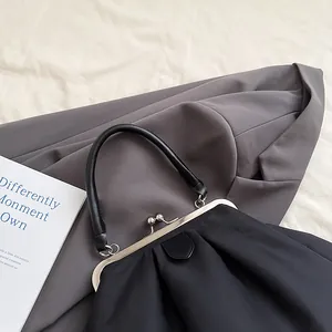 Detail of black pleated cloud bag with vintage silver metal clasp and matte leather