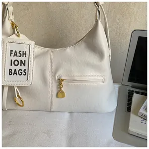 Detail view of beige PU leather texture and gold hardware on large hobo shoulder bag