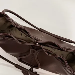 Detail of dark brown lychee grain leather tote with branded inner lining and drawstring