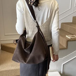 Close-up of brown matte bucket bag with adjustable strap and silver buckle detail