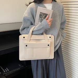 Detail of minimalist cream leather business tote bag with a front buckle pocket