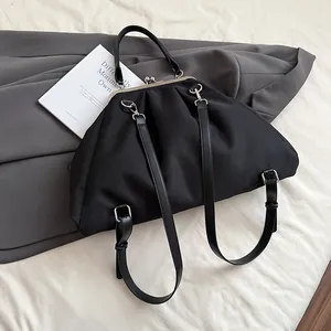 Detail of black pleated nylon cloud bag featuring retro metal frame clasp and soft texture