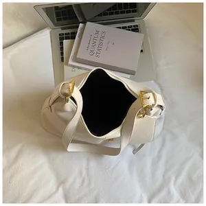 Detail of the golden square buckle and textured off-white leather on a large tote bag