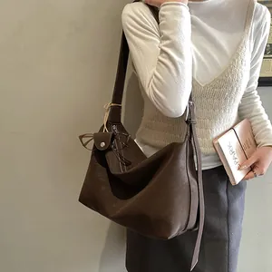 Macro detail of brown leather shoulder bag with adjustable strap and side buckle