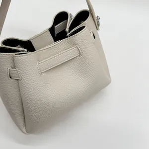 Macro shot of off-white lychee pattern leather bucket bag with premium texture