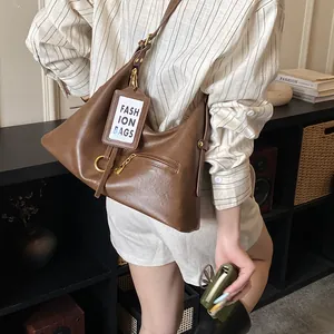 Detail view of large vintage brown leather tote bag with metal ring buckle and zip