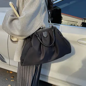 Fashionable black cloud handbag featuring elegant pleated texture and vintage metal clasp closure