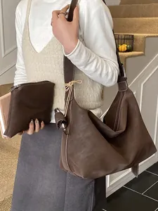 Deep brown matte leather hobo bag and matching pouch with white contrast stitching