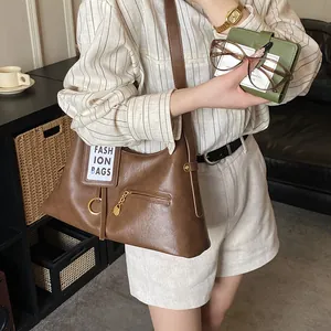 Detail view of brown PU leather bag side pocket with fashion card and chain ornament