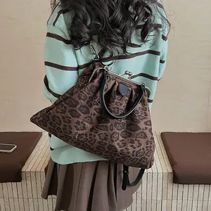 Detail view of retro leopard print clasp bag with black handle and vintage metal frame