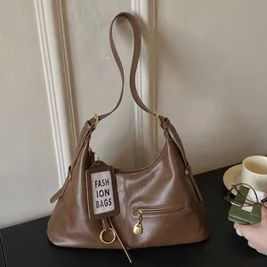 Detail of vintage brown leather tote with gold hardware and stylish card holder tag