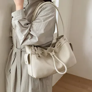 Detailed view of cream leather tote bag with drawstring closure and star pendants