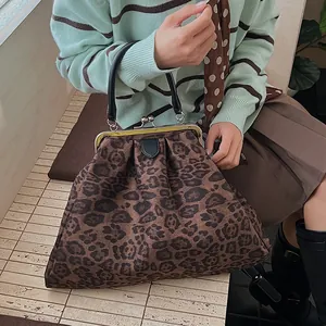 Close-up of retro leopard print fabric texture and black leather handle on handbag