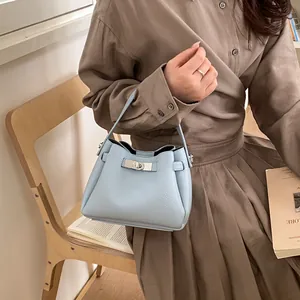 Close-up of light blue lychee pattern leather bucket bag with silver metal twist lock