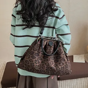 Detail of leopard print tote bag with vintage metal clasp and adjustable strap