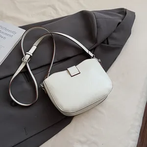 Detail of white saddle bag showing fine leather texture and brown oil edge contrast