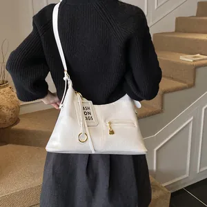 Detail of white PU leather tote with golden ring hardware and front zipper pocket