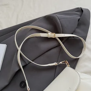 Gros plan sur le sac besace blanc montrant la texture du cuir PU et les détails dorés