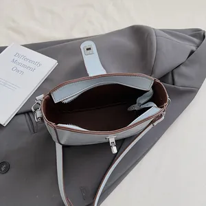 Detail shot of blue leather saddle bag interior showing silver zippers and inner pocket