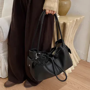 Close-up of black lychee grain leather tote bag with drawstring and star charms