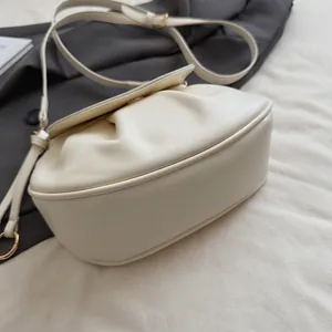 Détail du sac selle blanc cassé avec cuir mat plissé et plis latéraux effet nuage