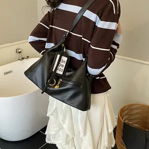 Detail of black faux leather tote bag with gold zipper and stylish fashion tag