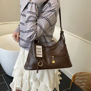Close-up of a vintage dark brown leather tote bag with gold hardware and logo tag