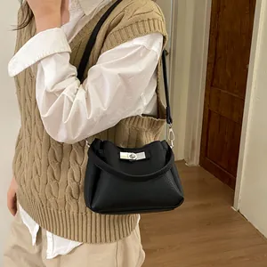 Detail of black pebbled leather texture and silver turn-lock buckle on vintage bucket bag