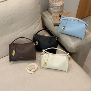 Detail view of four Boston bags in various colors featuring lychee grain leather and gold hardware