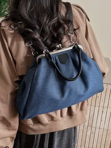 Blue denim pleated doctor bag shown as a backpack with vintage metal frame clasp