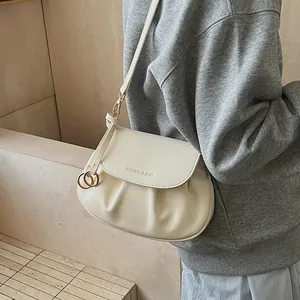 Détail du sac bandoulière plissé crème avec gravure Fashion & Bags sur le rabat