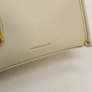 Detail of lychee pattern cream leather with gold Fashion & Bags lettering and hardware