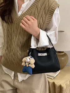 Retro black leather bucket bag with silver lock and plush puppy charm for daily wear