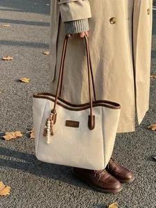 Retro cream tote bag with dark brown trim and beaded charm for commute use